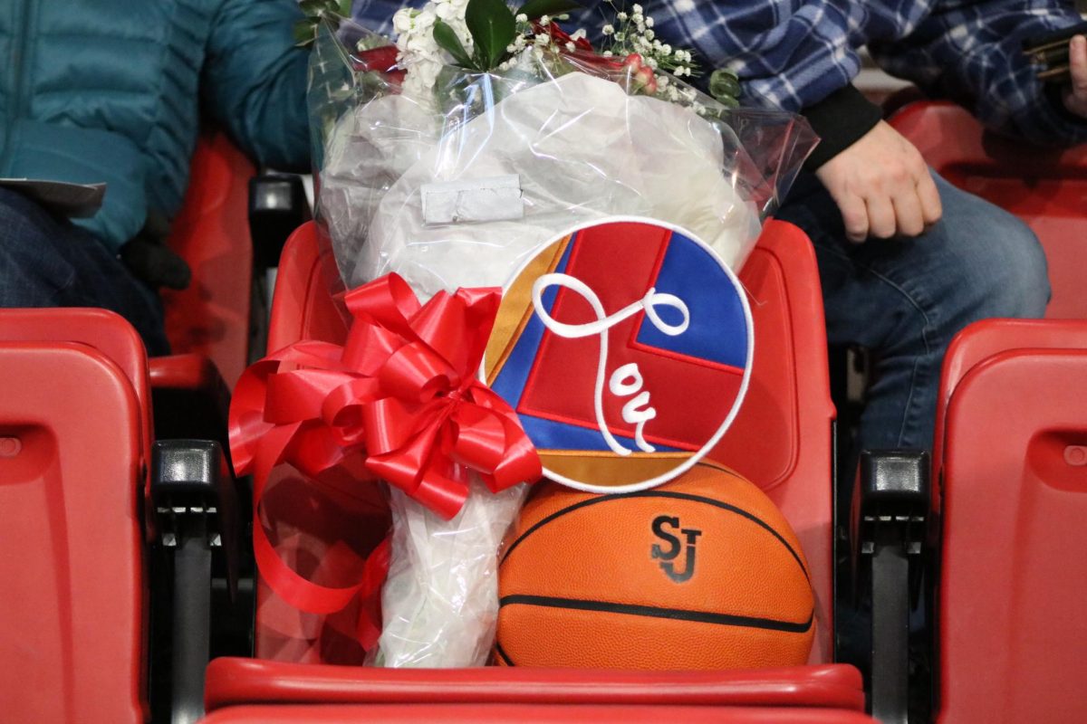 Flowers and a commemorative patch are placed in Lou Carnesecca's seat. 
Torch Photo / James Williams